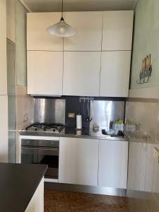 a kitchen with white cabinets and a stove at Lola a Moneglia in Moneglia