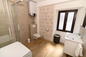 a bathroom with a shower toilet and a sink at Apartman Ciciliani in Trogir