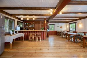 H̱aluẕにあるThe Scandinavian Village-Teva BaHarのテーブルと椅子が備わるウッドフロアのレストランを併設しています。