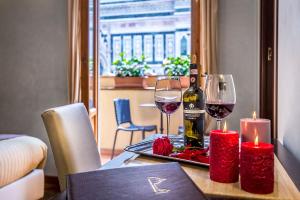 a table with a bottle of wine and two glasses at Hotel Duomo Firenze in Florence