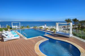a swimming pool with chairs and the ocean in the background at Sunrise Arabian Beach Resort in Sharm El Sheikh