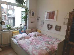 - une chambre avec un lit avec des draps roses et une fenêtre dans l'établissement Penthousewohnung 126 qm Bremen Innenstadt+ Dachterrasse, à Brême