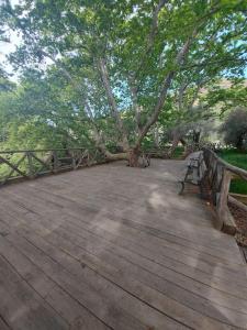 un puente de madera con un árbol y un banco en Horio House, en Límni