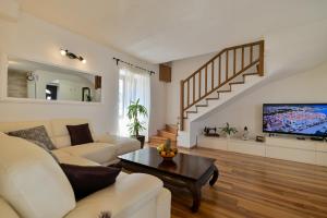 a living room with a couch and a tv at Apartman Ciciliani in Trogir