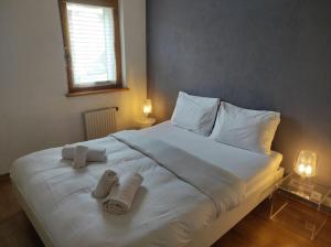 1 cama blanca grande con 2 toallas en Family friendly 2-Bedroom near Golf & Ski slopes en Lens
