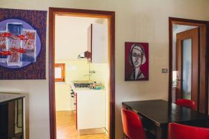 Vico Canavese的住宿－La casa del Viandante，厨房配有黑桌和红色椅子