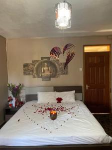 a bedroom with a white bed with roses on it at Riambel Paradise Inn Private Apartment in Riambel