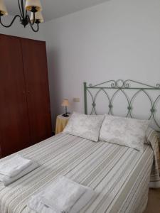ein Schlafzimmer mit einem großen Bett mit zwei Handtüchern darauf in der Unterkunft Apartamento Playa de Esteiro in Ribadeo