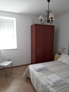 a bedroom with a bed and a chair and a window at Apartamento Playa de Esteiro in Ribadeo
