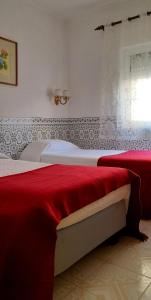 a bedroom with two beds and a window at Casa da Forja in Pinhal Novo