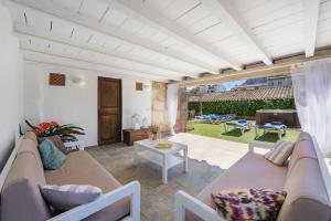 a living room with a couch and a table at Es Garroverar in Pollença