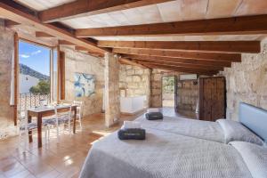 a large room with two beds and a table at Es Garroverar in Pollença +13 photos