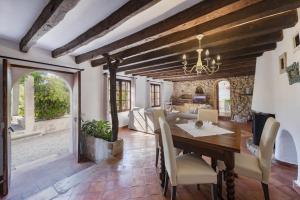 a kitchen and dining room with a table and chairs at Es Garroverar in Pollença