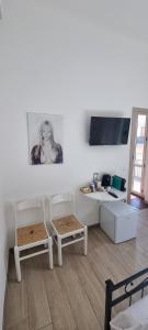 a living room with two white chairs and a table at B&B D'AMARE in Cupra Marittima
