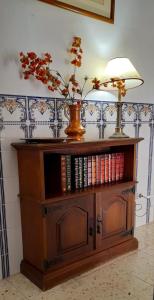 un estante de libros con una lámpara y un jarrón. en Casa da Forja en Pinhal Novo