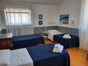 Habitación de hotel con 2 camas y mesa en Verde Blu Lakefront Boutique Holiday Apartments Trevignano Romano en Trevignano Romano