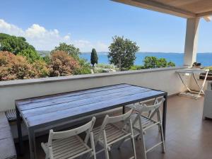 una mesa y sillas en un balcón con vistas al océano en Verde Blu Lakefront Boutique Holiday Apartments Trevignano Romano en Trevignano Romano