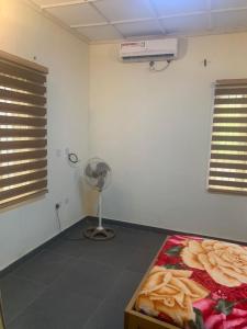 Cette chambre comprend un lit et un ventilateur. dans l'établissement Modern Bungalow in Idi Aba, à Abeokuta