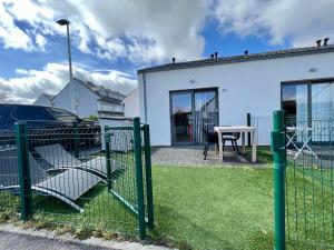 einen Zaun mit Stühlen und einem Tisch vor einem Haus in der Unterkunft Melroce Holiday Cottage 5502 in Bredene