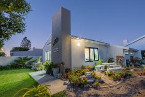 ein Haus mit Garten davor in der Unterkunft Oceans Cottage Struisbaai in Struisbaai