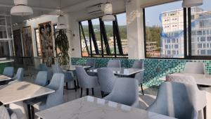 a restaurant with blue chairs and tables and windows at Phúc Thắng Hotel in Phú Quốc