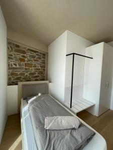 1 dormitorio con cama y pared de piedra en API Tenna Apartaments Betulla 2 en Tenna 