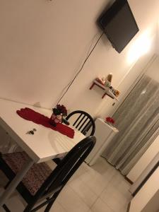 mesa de comedor con TV, mesa y sillas en B&B Le Magnolie en Amorosi
