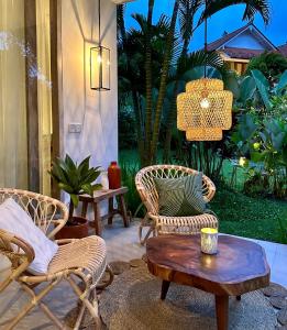 a patio with two chairs and a coffee table at The White Villas Ubud in Ubud