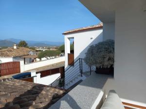 ein weißes Haus mit einem Balkon mit einer Pflanze in der Unterkunft Casa Vacanze Zeffiro vista mare con giardino in Àrbatax