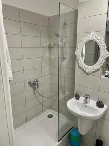 La salle de bains est pourvue d'une douche, d'un lavabo et d'un miroir. dans l'établissement Ayan Residance Desilva, à Mamaia