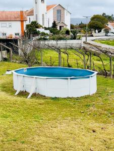 una gran bañera blanca sentada en un campo de hierba en Casa da Lagoa, en Alvarães