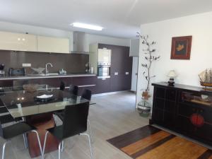 a kitchen and dining room with a table and chairs at Casa da Lagoa in Alvarães