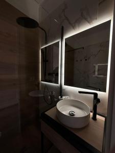 baño con lavabo y espejo grande en Rhospitality - Visconti Affittacamere, en Rho