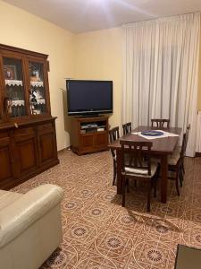 un salon avec une table et une télévision dans l'établissement De Nicolò Home, à Putignano