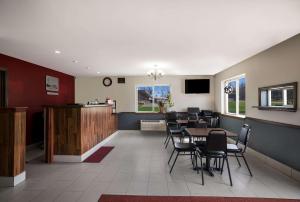 una sala de espera con mesas, sillas y un mostrador en Econo Lodge Inn & Suites, en Canandaigua