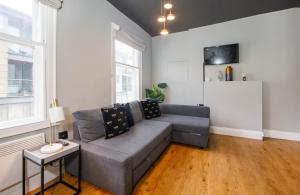 a living room with a gray couch and a table at Turpin Quarter in the centre of the city, sleeps 6 in York