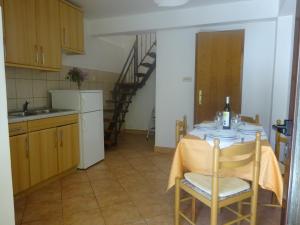 a small kitchen with a table and a staircase at Apartment and Rooms Milena in Mošćenička Draga