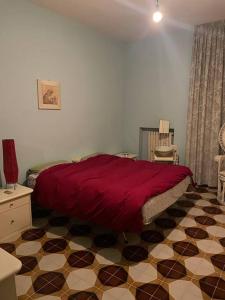 - une chambre dotée d'un lit rouge et de carrelage dans l'établissement De Nicolò Home, à Putignano