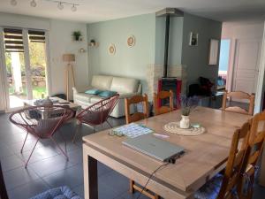 Gite Les Cimes في لابريس: غرفة معيشة مع طاولة مع لاب توب عليها