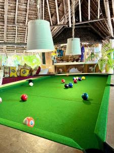 a green pool table with balls on it at Rock and Sea Resort in Watamu