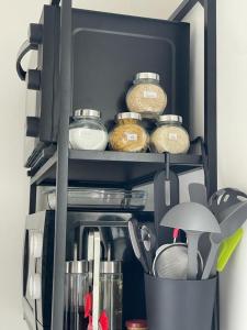 a kitchen utensils and other items in a cabinet at Studio T à 5mn euro airport avec terrasse in Saint-Louis