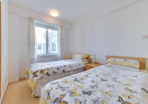 2 Betten in einem Zimmer mit Fenster in der Unterkunft St Margarets Flat in Rottingdean
