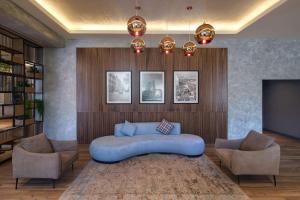 a living room with a blue couch and two chairs at Radisson Hotel Baku in Baku