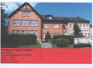 a large brick building with a sign in front of it at Gasthof zum alten Schulmeister in Harra
