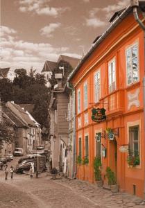ein orangefarbenes Gebäude auf einer Straße in einer Stadt in der Unterkunft Hotel Casa Wagner in Sighişoara