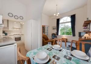 a kitchen and living room with a table and chairs at Kemp Town Mews in Brighton & Hove