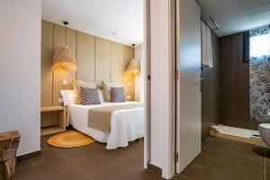 a hotel room with a bed and a shower at Migjorn Ibiza Suites & Spa in Playa d'en Bossa
