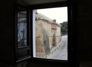 een raam met uitzicht op een oud bakstenen gebouw bij Casa de San Lorenzo in Úbeda