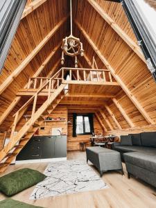una gran sala de estar con techos de madera y una escalera. en Gültepe Bungalov, en Ardeşen