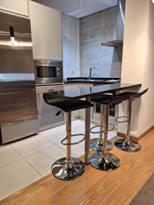 a kitchen with a counter with two bar stools at Bracara Guest House "Arcada" in Braga